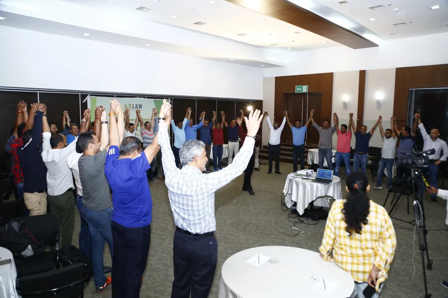 The L&W management team joining hands at the close of a Build to Grow session
